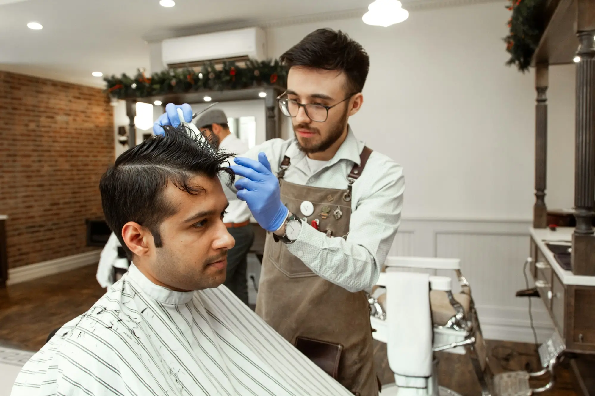 Barber cutting a client's hair, a small business owner comparing small business loans