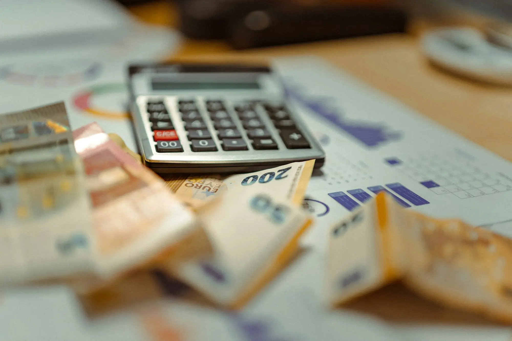 Calculator sitting on banknotes, working out tax debt and the cost of a loan