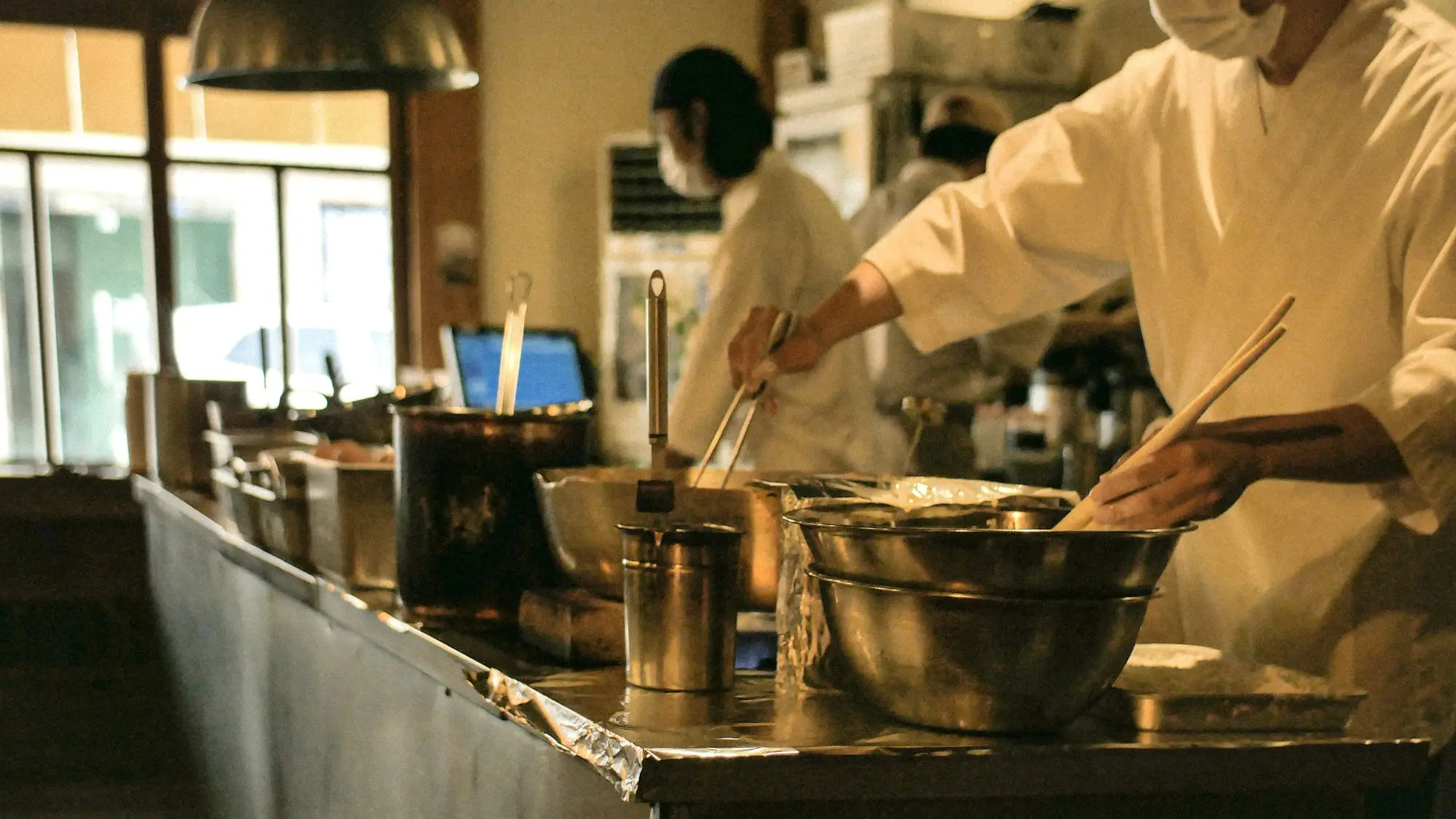 Chef cooking in a busy kitchen, a business with uneven weekly takings choosing a repayment style