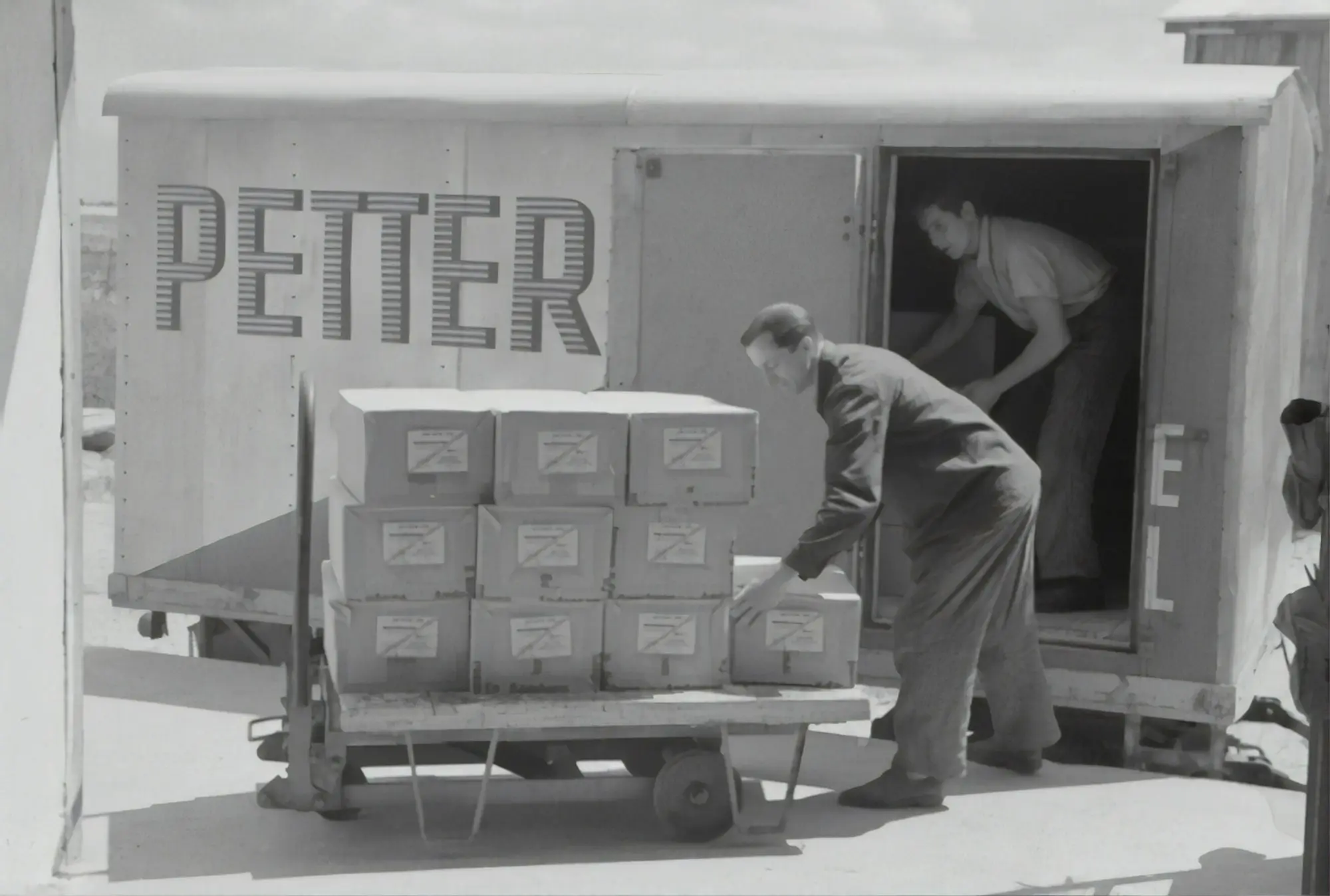 Worker beside stacked cardboard boxes in a warehouse, stock funded with working capital